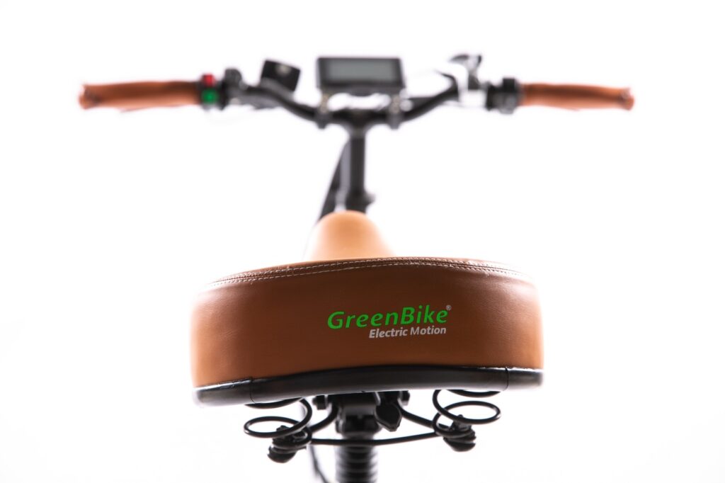 אופניים חשמליים עם מושב חום, לוגו GreenBike, נראות ממבט על, רקע לבן.
