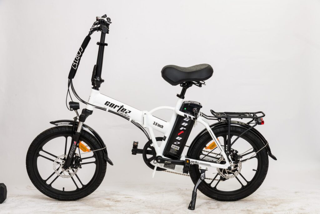 אופניים חשמליים מתקפלים בצבע לבן עם סוללה ומערכות בלימה מתקדמות, מוכנים לרכיבה עירונית.